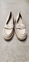 Front view of the white leather-look Madden Girl wedge loafers size 8.5, showing slip-on style with strap detail.