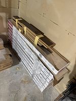 Stacked boxes of Wilsonart Flooring Tap-N-Lock and loose dark wood stain planks strapped on top