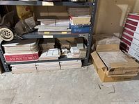 Shelving with multiple stacks of interior tiles including porcelain and ceramic types, various sizes, and finishes