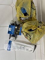 Two yellow bags filled with multiple unopened packages of solar glass crackle path lights on stakes, plus some loose packages on the floor.