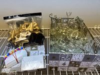 Various name place card holders and cards arranged in decorative box, including wooden clips, acrylic heart-shaped holders, and metal heart clip holders.