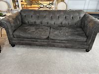 Front view of gray chesterfield sofa showing full seating, tufted back and seat cushions