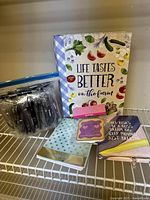 Keepsake box with farm theme text, three notepads, and bag of Deloitte branded pens on shelf