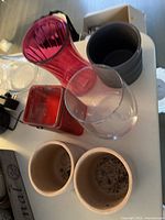 Overview of the flower pots and vases, showing a mix of ceramic and glass items including the pink fluted vase and clear rounded vase.