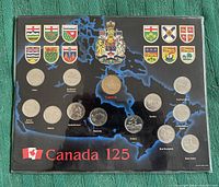 Photo of Canada 125 uncirculated coins set in a display card depicting Canadian map and provincial crests