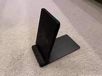 Black wireless charger stand upright showing charging symbol and foldable base