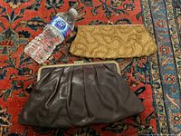 Both clutch bags shown side by side on patterned carpet with water bottle for scale.