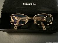 Top view of Tiffany & Co. vintage glasses in the open original case, showing rectangular lens frames and translucent arms.