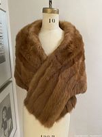 Full front view of cinnamon mink stole draped on mannequin showing overall shape and color.
