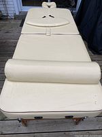 Top view of the cream vinyl massage table fully extended with bolster and face rest in place.