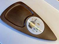 Photo of the entire cheeseboard showing the surfboard shape, carved wooden surface, and inset ceramic tile.