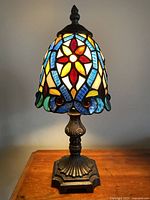 Full view of the small stained glass night lamp, showing the colorful floral patterned glass shade illuminated.