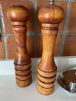 Front view of the vintage Baribocraft pepper grinder and salt shaker showing wood grain and finishes