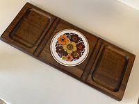 Full view of the wooden cheeseboard showing the three compartments and the central floral ceramic tile.