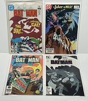 Overview of four DC Batman comic books in protective bags, laid out on flat surface.
