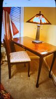 Desk and chair positioned near window with a lamp on top, showing overall appearance
