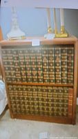 Full view of the solid wood shelf unit containing 24 volumes of the 1948 Encyclopedia Britannica. Books have dark covers with gold embossed titles.