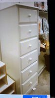 View of front showing six drawers and white round knobs on solid wood lingerie chest.