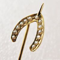 Close-up front view of wishbone motif showing seed pearl arrangement