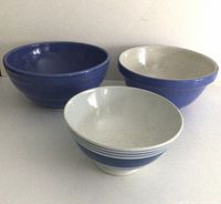 Three antique English mixing bowls shown together, blue and white color, varied sizes