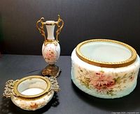 Photo of three Victorian Wavecrest glass pieces with hand painted floral design and ormolu accents: planter, vase, and dresser dish.