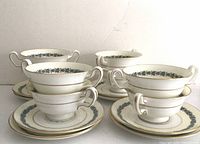 Eight sets of double-handled Wedgwood soup bowls with matching saucers arranged in two rows, showing the front and side views.