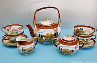 Full tea set displayed showing teapot, cream pitcher, covered sugar bowl, four cups and saucers with colorful Japanese scenery and geisha lithophane bottoms in cups.