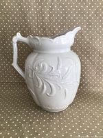 Side view showing raised embossed wheat and swirl patterns on the jug surface and the handle shape.