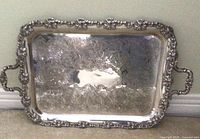 Photo showing entire rectangular silver plated tray with ornate grape and vine border and etched center design, slight tarnish visible.