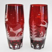Front views of both crystal vases showing engraved birds and forest scenes on red cut-to-clear crystal.