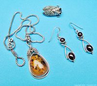 Full lot: necklace, earrings, brooch on blue background