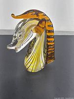 Side angle showing amber glass mane with stripes and clear front muzzle with detailed black line accents