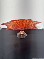 Front and angled view of the large Murano glass bowl showing orange accent and flower petal shape on clear pedestal.