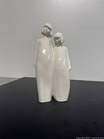 Front angle showing both stylized female figures with bobbed hair and glossy white finish.