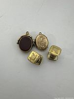 Photo showing two gold-filled pendants and a pair of cufflinks with Masonic insignia on white background.