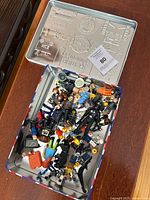 Metal tin containing assorted LEGO figures and accessories