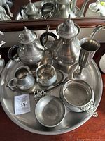 Photo showing complete pewter tea and coffee set with tray and accessories from front angle.