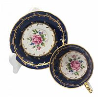 Top view of cup and saucer showing floral design with gold leaf vine pattern on cobalt blue border