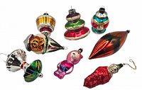 Full view of eight vintage glass Christmas ornaments in various shapes and colors including a teardrop, clown cone, bear, and pepper shaped ornament.