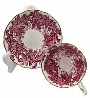Porcelain cup and saucer with purple leaf design on stand