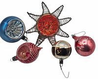 Top view of five vintage glass Christmas tree ornaments in various shapes and colors including two starbursts and three bulb ornaments.