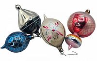 Four vintage glass Christmas tree ornaments of various shapes and colors, lying together to show variety