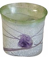 Side angle view showing clear textured glass, purple swirls inside, and green rim