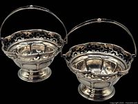 Photo showing both miniature silver baskets with handles in upright position, displaying size and shape.