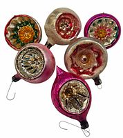 Six vintage glass Christmas tree ornaments arranged showing colors and embossed designs, including the larger red one marked East Germany.