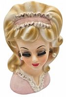 Front view of the ceramic head vase showing detailed facial features, hair, and pink dress