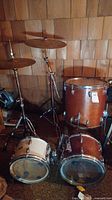 Three tom drums arranged on floor with one cymbal on stand