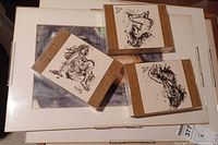 Three small framed ink sketches on a white backing