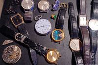 Full overview of watches including pocket watches, wristwatches, and loose watch parts