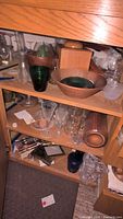 Wooden cabinet containing wood serving ware and glassware including bowls and tumblers